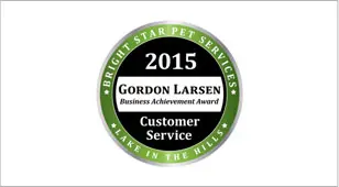 A green and white award with the words " gordon larsen business achievement award customer service " on it.