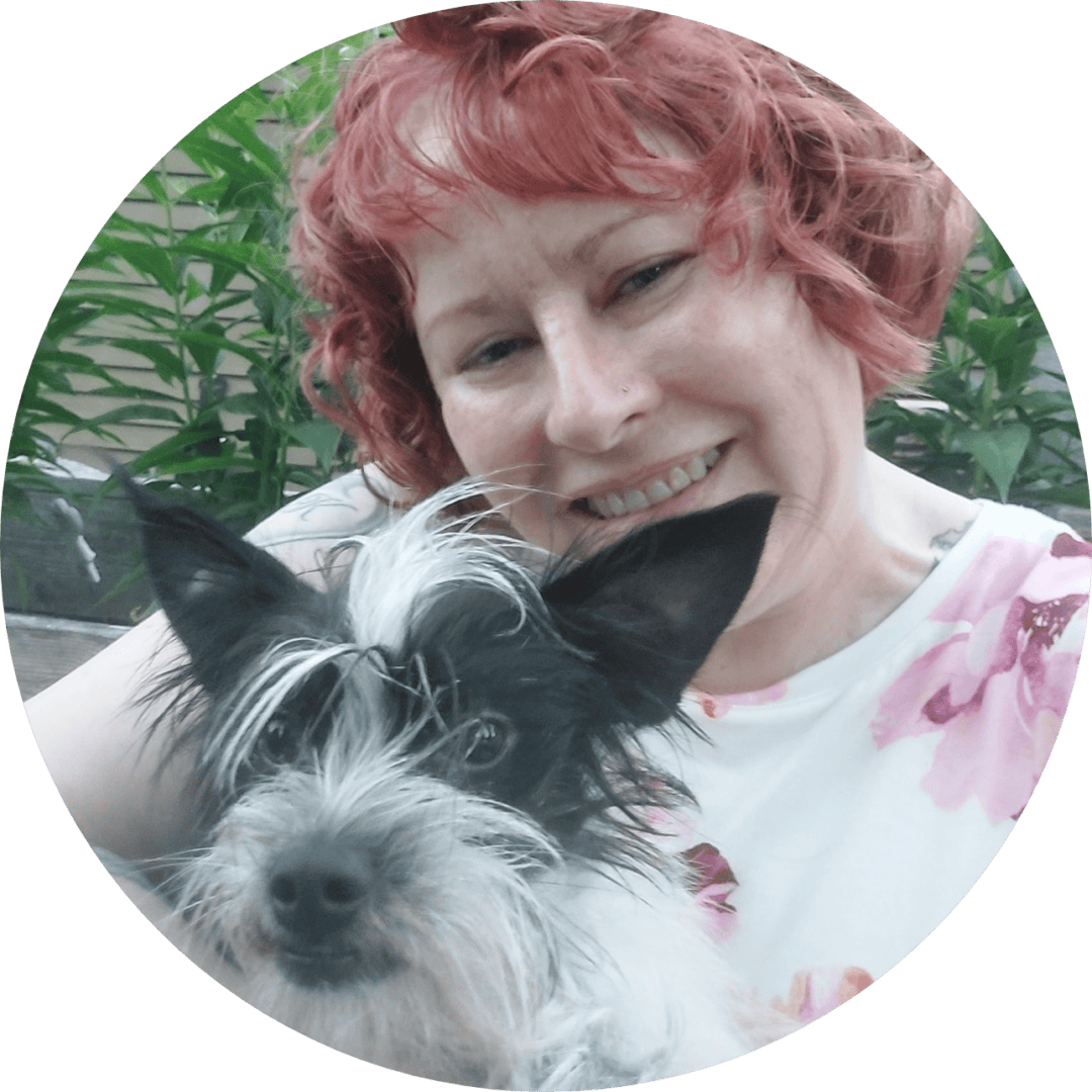 Smiling person with small black and white dog